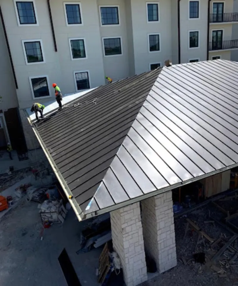 Crew installing standing seam metal roof panels on a commercial project in Waynesboro